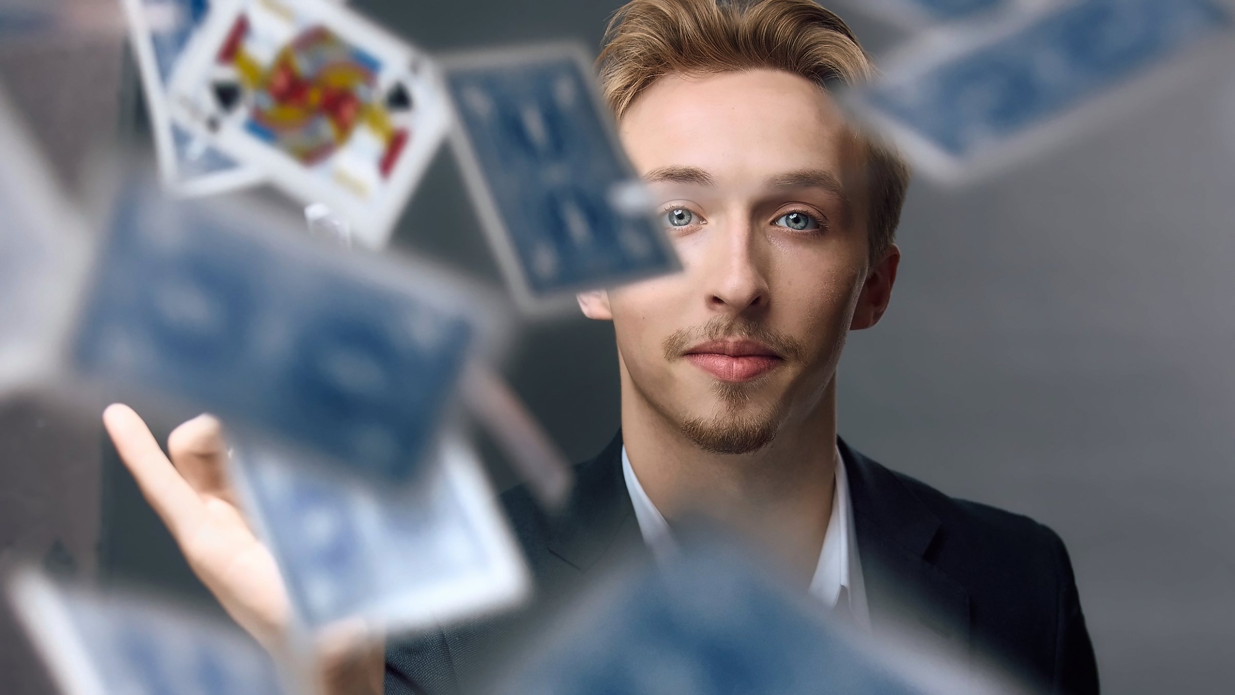 Tom Gibney behind a burst of falling playing cards