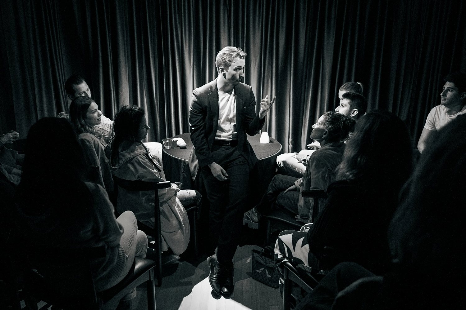 Tom performing inside a circle of seated guests