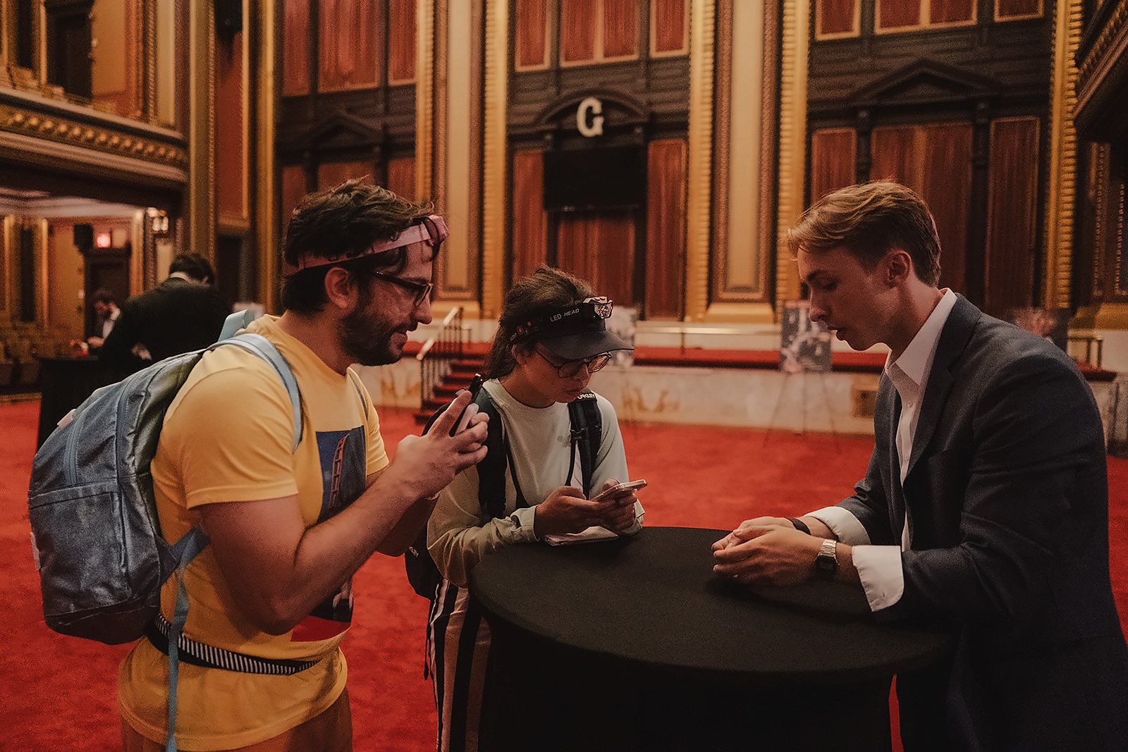 Tom performing at a cocktail table in a grand hall