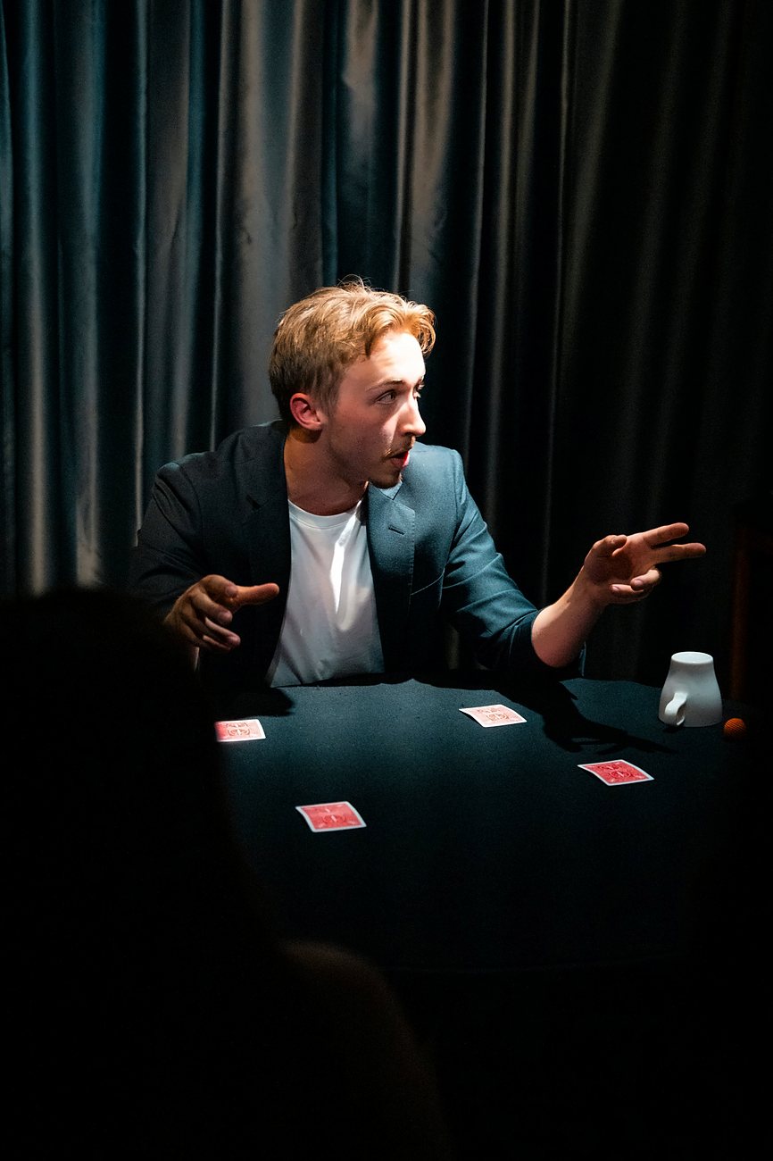Tom at a table with four red cards