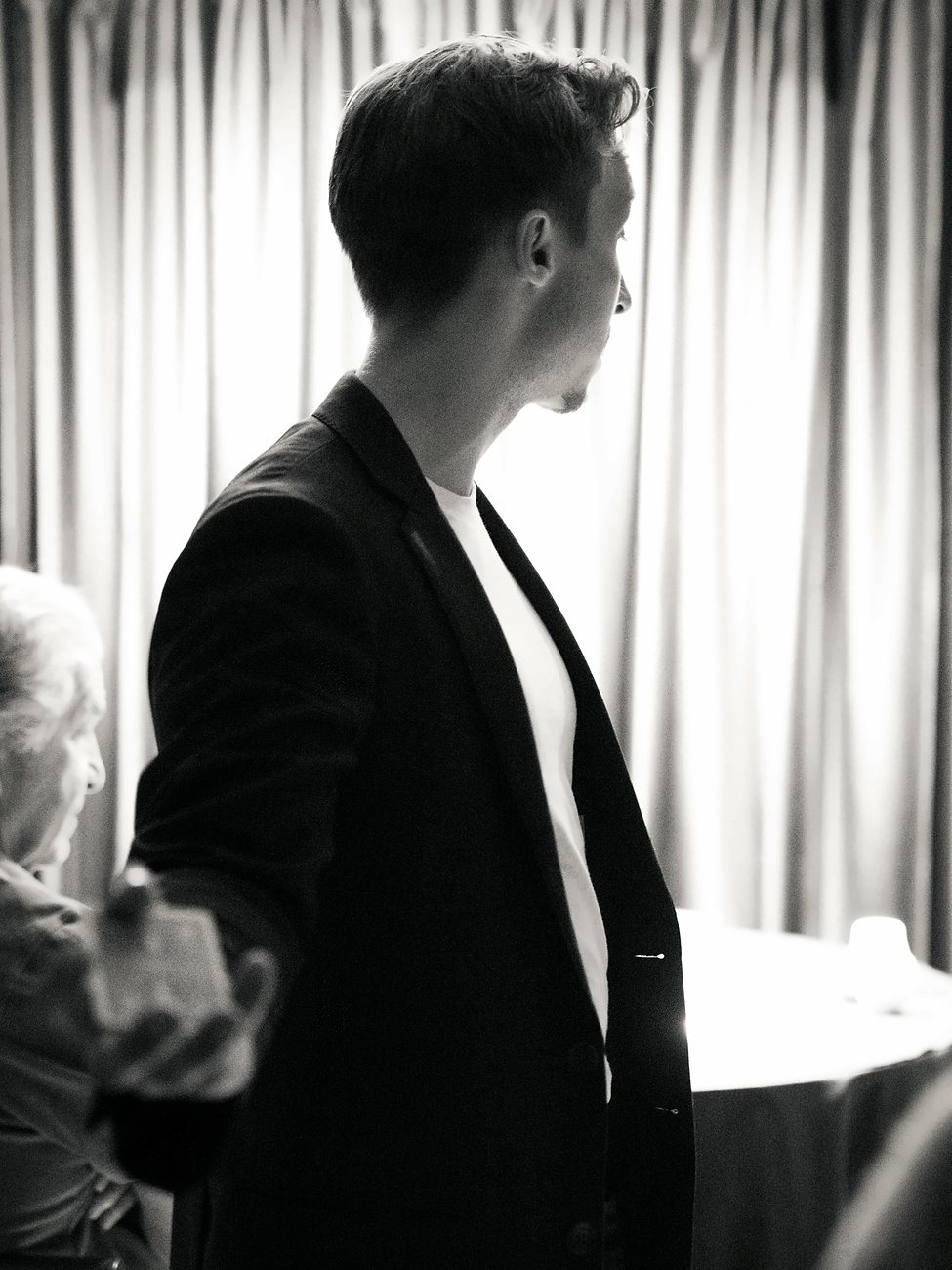 Tom in profile against a bright curtain