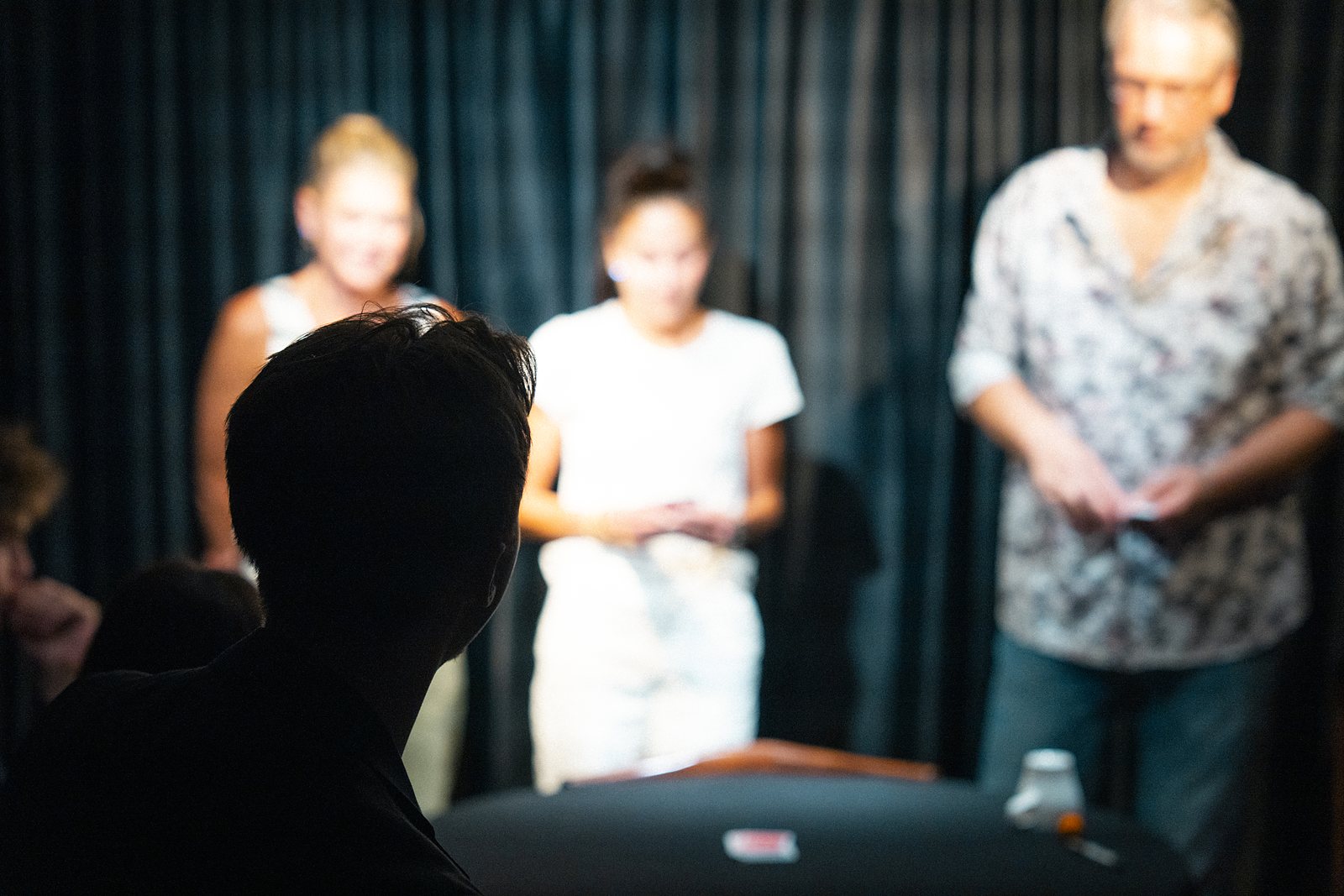 Guests standing at the close-up table under a spotlight