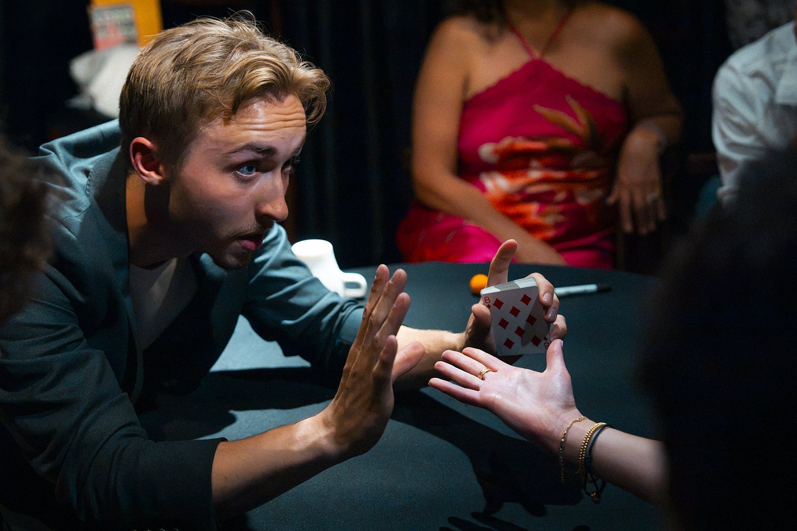 Tom pressing his hand against a guest's palm across the table