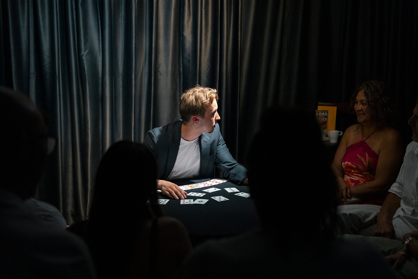 Tom performing for a full table of guests