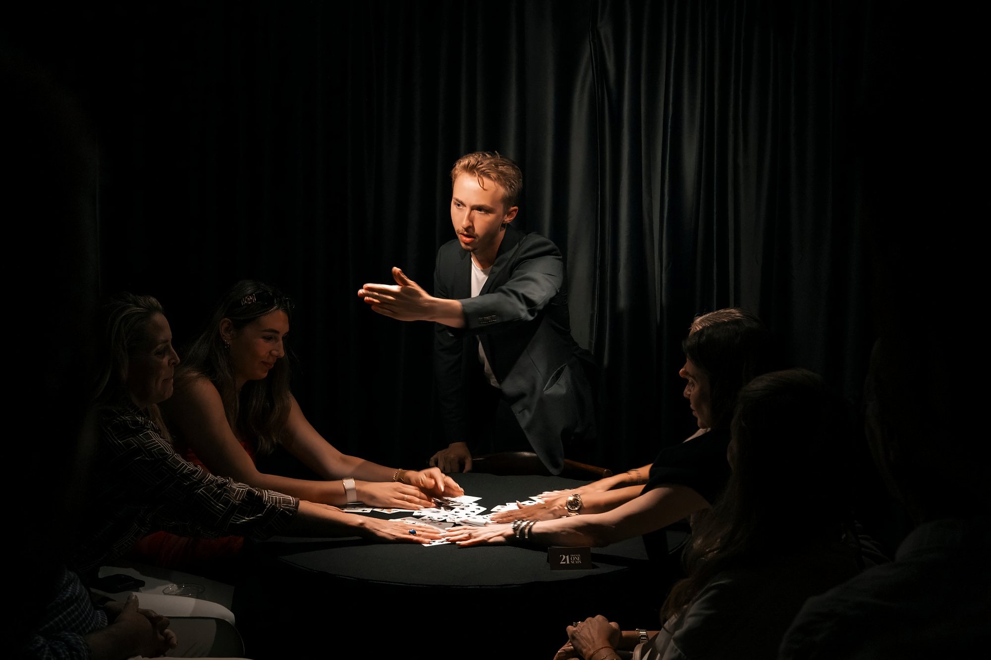 Guests with hands on a spread of cards